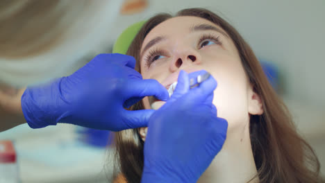 La-Dentista-Saca-Un-Tampón-De-Algodón-De-La-Boca-Abierta-Del-Paciente