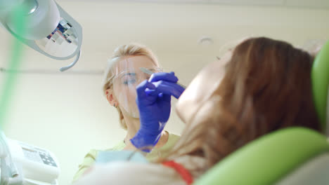 Zahnärztin-Steckt-Baumwolltampon-In-Den-Offenen-Mund-Des-Patienten.-Behandlungsprozess