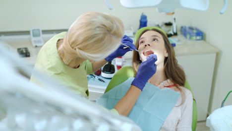 Dentalhygienikerin-Untersucht-Patientenzähne-Mit-Mundspiegel-Und-Zahnsonde