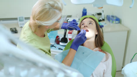 Stomatology-doctor-working-in-dental-clinic.-Female-patient-on-review-of-dentist