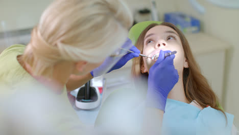 Zahnbehandlungsprozess-In-Der-Zahnarztpraxis.-Blonder-Zahnarzt,-Der-Mit-Dem-Patienten-Arbeitet