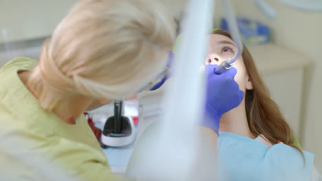 Dentista-Haciendo-Limpieza-Dental-Profesional-De-Una-Paciente-En-Una-Clínica-Dental