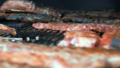 Side-view-chef-grilling-beef-for-party.-Closeup-cook-barbecuing-meat-in-marinade