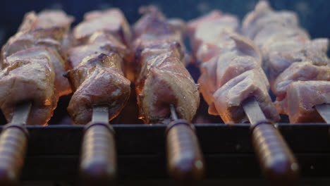 Closeup-pork-kebabs-grilling-on-open-fire.-Beef-shashlik-on-metal-skewers.