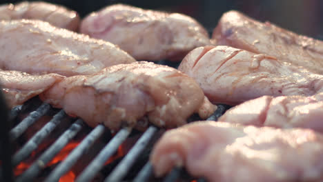 Closeup-raw-chicken-breasts-on-barbeque-grill.-Chicken-fillet-grilling-on-fire