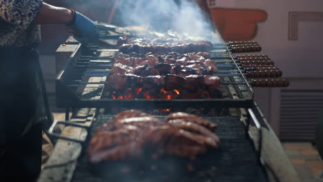Chef-Hombre-Cocinando-Carne-A-La-Parrilla.-Manos-Del-Chef-Cocinando-Kebabs-En-El-Brasero.