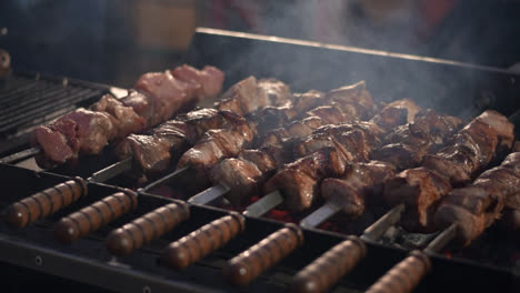 Closeup-pork-kebabs-barbecuing-at-brazier.-Bbq-meat-grilling-on-skewers
