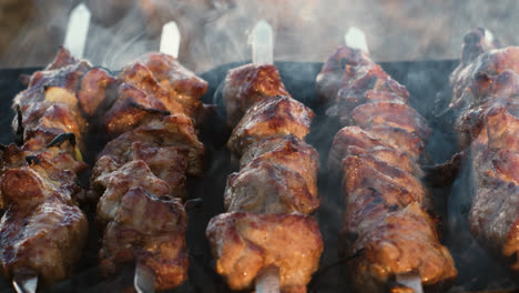 Closeup-pork-kebabs-cooking-on-grill-outdoor.-Grilling-smoked-bbq.