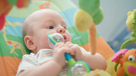 Infant-playing-baby-rattle.-Sweet-baby-face-with-toy.-Adorable-kid-with-rattle