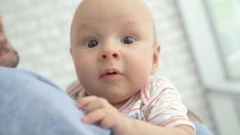 Babygesicht-Schaut-In-Die-Kamera.-Porträt-Eines-Entzückenden-Kindes-In-Den-Händen-Des-Vaters