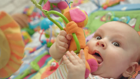 Cute-baby-gnawing-toys.-Sweet-parenthood.-Lovely-boy-with-rattle