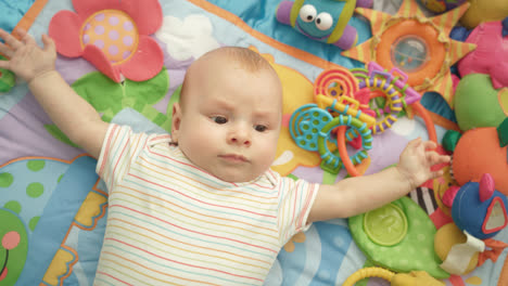 Little-baby-boy-on-colorful-carpet.-Portrait-of-infant-relaxing-on-mat
