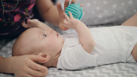 Niedliches-Baby,-Das-Ein-Blaues-Spielzeug-Hält.-Entwicklung-Des-Neugeborenen.-Schönes-Kind-Studiert-Die-Welt