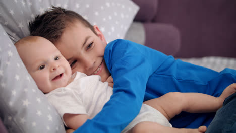 Portrait-of-boy-embracing-infant.-Happy-siblings-with-baby.-Happy-brothers