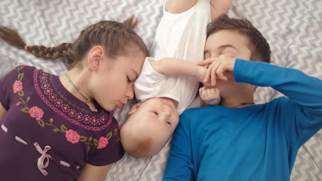 Three-children-together.-Portrait-of-happy-siblings-kissing-baby-brother