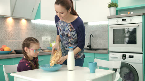 Mom-cooking-breakfast-for-daughter.-Mother-preparing-food-for-child-at-morning