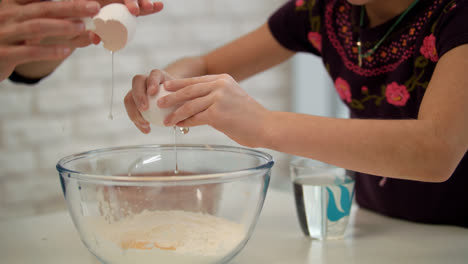 Cooking-hands-breaking-eggs.-Preparing-breakfast-together.-Mom-with-kid-cooking