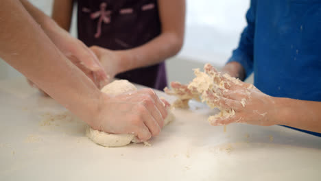 Mother-hand-cooking-with-children.-Mom-cooking-with-kids.-Dough-hands-in-kitchen
