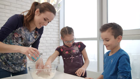 Cooking-family-have-fun-on-kitchen.-Woman-cooking-cake-with-childrens