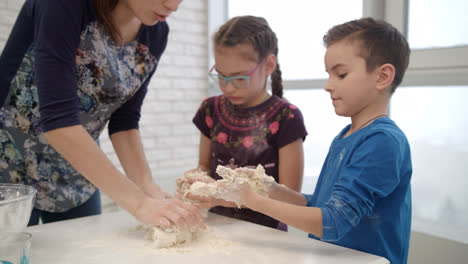 Little-chef-cooking-dough-with-mom.-Children-cooking-dough-with-mom
