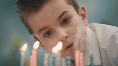 Birthday-boy-blowing-candle-flame-on-cake.-Happy-birthday-party