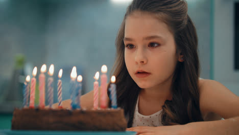 Portrait-of-girl-blowing-candles-in-slow-motion.-Child-happy-birthday-concept