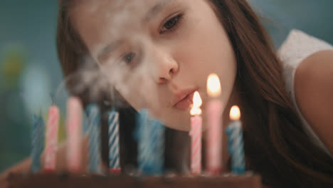 Pretty-girl-blowing-candle-flame-on-birthday-cake-in-slow-motion.-Happy-birthday