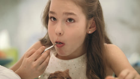 Pretty-girl-eating-chocolate-cake.-Portrait-of-kid-eating-birthday-cake