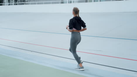 Woman-with-artificial-limb-jogging-on-track.-Athlete-running-on-sport-stadium