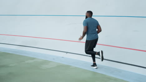 Afro-runner-training-on-sports-track.-Sporty-man-running-on-athletics-track