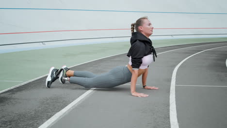 Handicapped-woman-practicing-yoga-on-stadium.-Sportswoman-exercising-on-track
