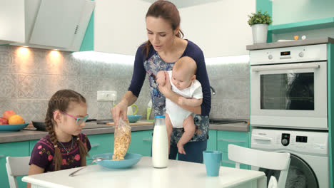 Mutter-Mit-Baby-Kocht-Gesundes-Frühstück-Für-ältere-Tochter