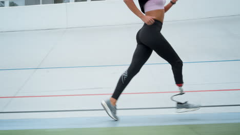Handicapped-female-jogger-running-on-racetrack.-Fitness-girl-training-outdoors