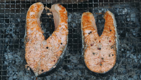 Cook-hand-seasoning-salmon-steak-black-pepper-peas.-Salmon-bbq-grilling-on-grill