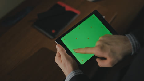 Männliche-Hand-Hält-Tablet-PC-Mit-Grünem-Bildschirm.-Nahaufnahme-Eines-Mannes,-Der-über-Den-Tablet-Bildschirm-Wischt