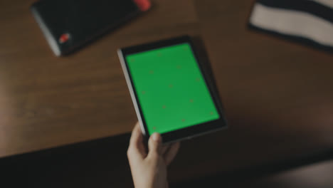Weibliche-Hand-Hält-Tablet-Mit-Grünem-Bildschirm.-Nahaufnahme-Eines-Tablet-PCs-Mit-Grünem-Bildschirm