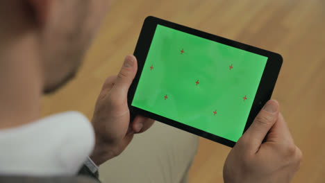 Mann-Hält-Tablet-Mit-Grünem-Bildschirm-In-Den-Händen.-Männliche-Hände-Wischen-über-Den-Tablet-Bildschirm