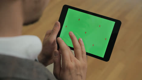 Male-hands-swiping-tablet-green-screen.-Man-touching-chromakey-screen-on-tablet