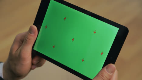 Male-hands-holding-ebook-with-green-screen.-Closeup-tablet-with-chromakey-screen