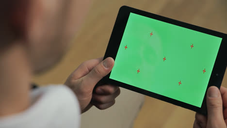Junger-Mann-Hält-Tablet-PC-Mit-Grünem-Bildschirm.-Männliche-Hände-Berühren-Den-Tablet-Bildschirm