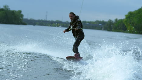 Young-man-on-wakeboard-dissecting-river-waves-in-slow-motion.-Extreme-holidays