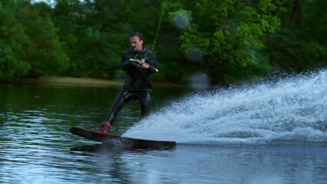 Man-riding-wakeboard-on-motorboat-wave.-Rider-in-training-wake-boarding