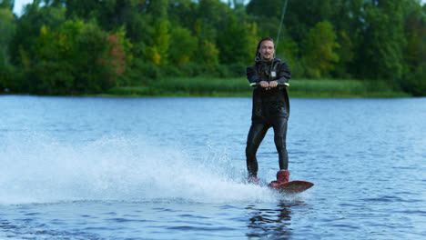 Young-man-riding-wakeboard-on-summer-lake.-Man-enjoying-extreme-holidays