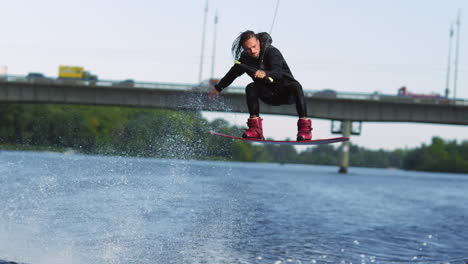Wakeboarder-Springt-Hoch-über-Wasser.-Profisportler-Macht-Trick
