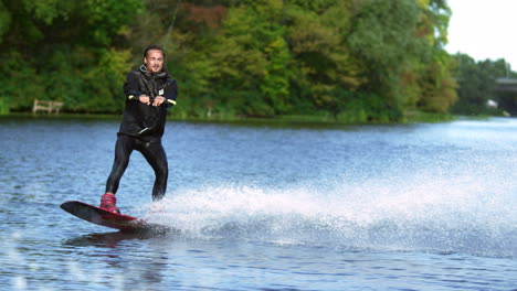 Handsome-man-wakesurfing-in-water-splashes.-Young-man-riding-wakeboard