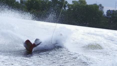 Man-riding-on-wakeboard-falling-into-water.-Sportsman-jumping-on-wakeboard