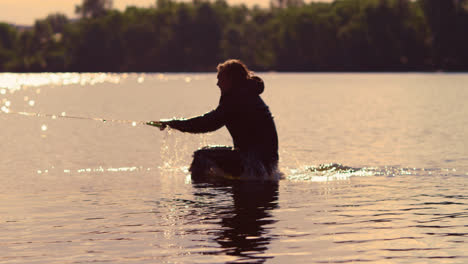 Man-start-wakebording-at-sunset.-Extreme-lifestyle.-Riding-on-water