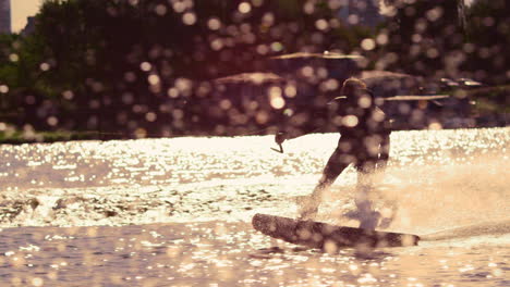 Man-riding-wakeboard-at-sunset.-Extreme-lifestyle.-Rider-enjoy-extreme-vacation