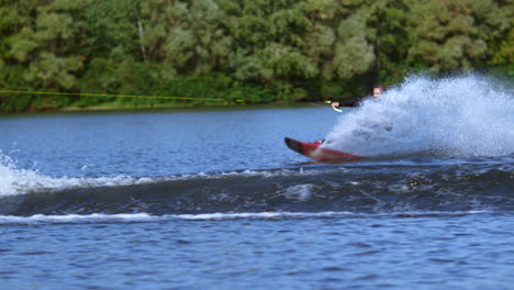 Young-man-rushing-on-water-board-on-water-behind-motorboat.-Extreme-water-sports
