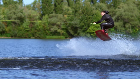 Wakeboarder-jumping-over-water-wave.-Slim-man-wakeboarding-above-water